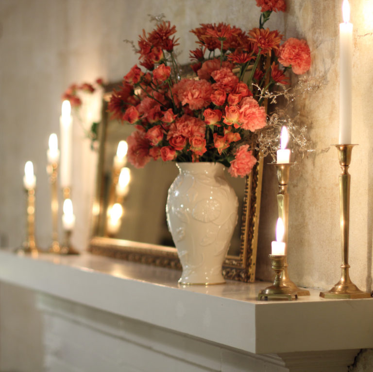 peach flower mantel with glowing candles