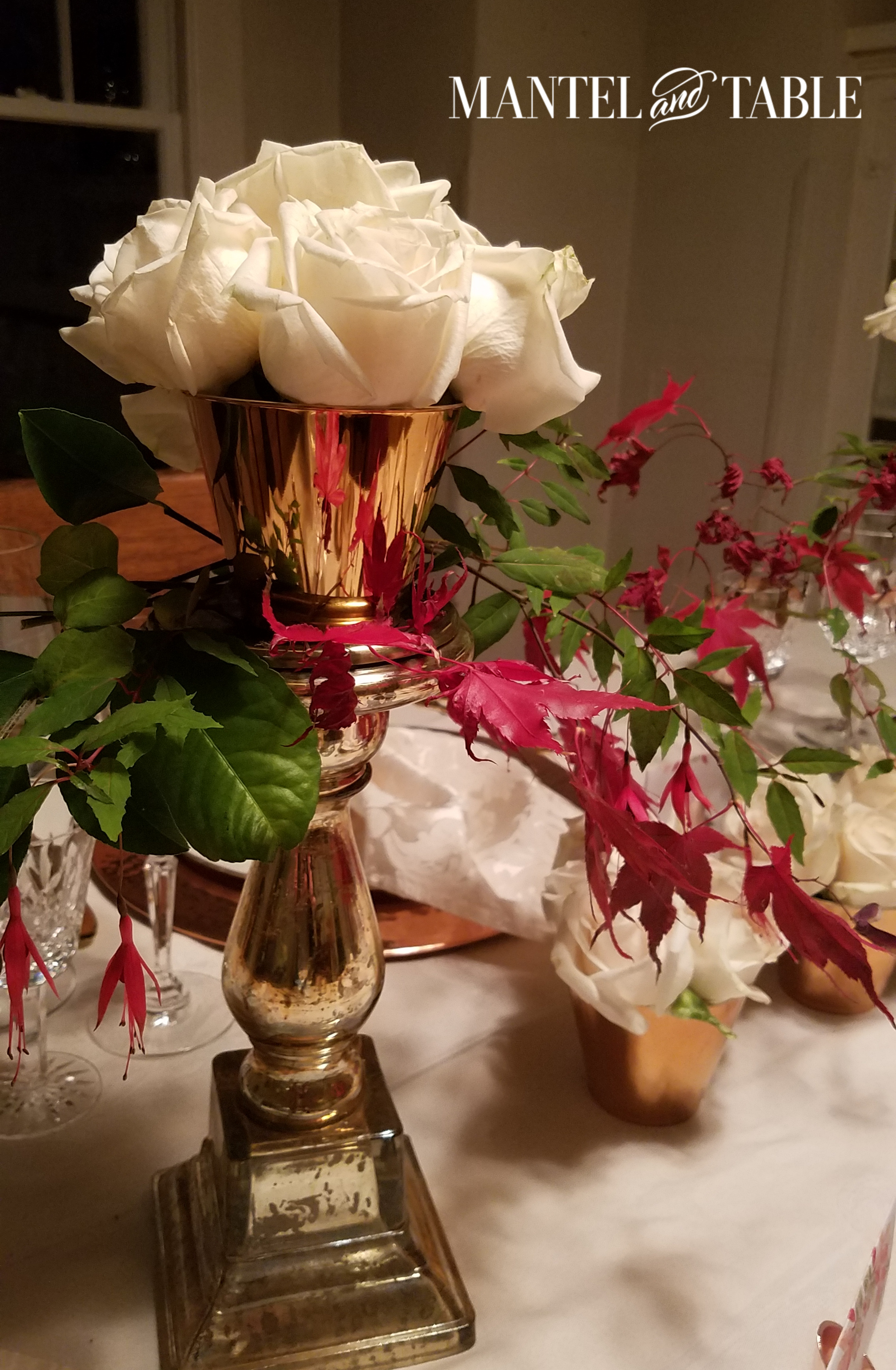 Thanksgiving table with gold candlestick with little copper cup of white roses on top!