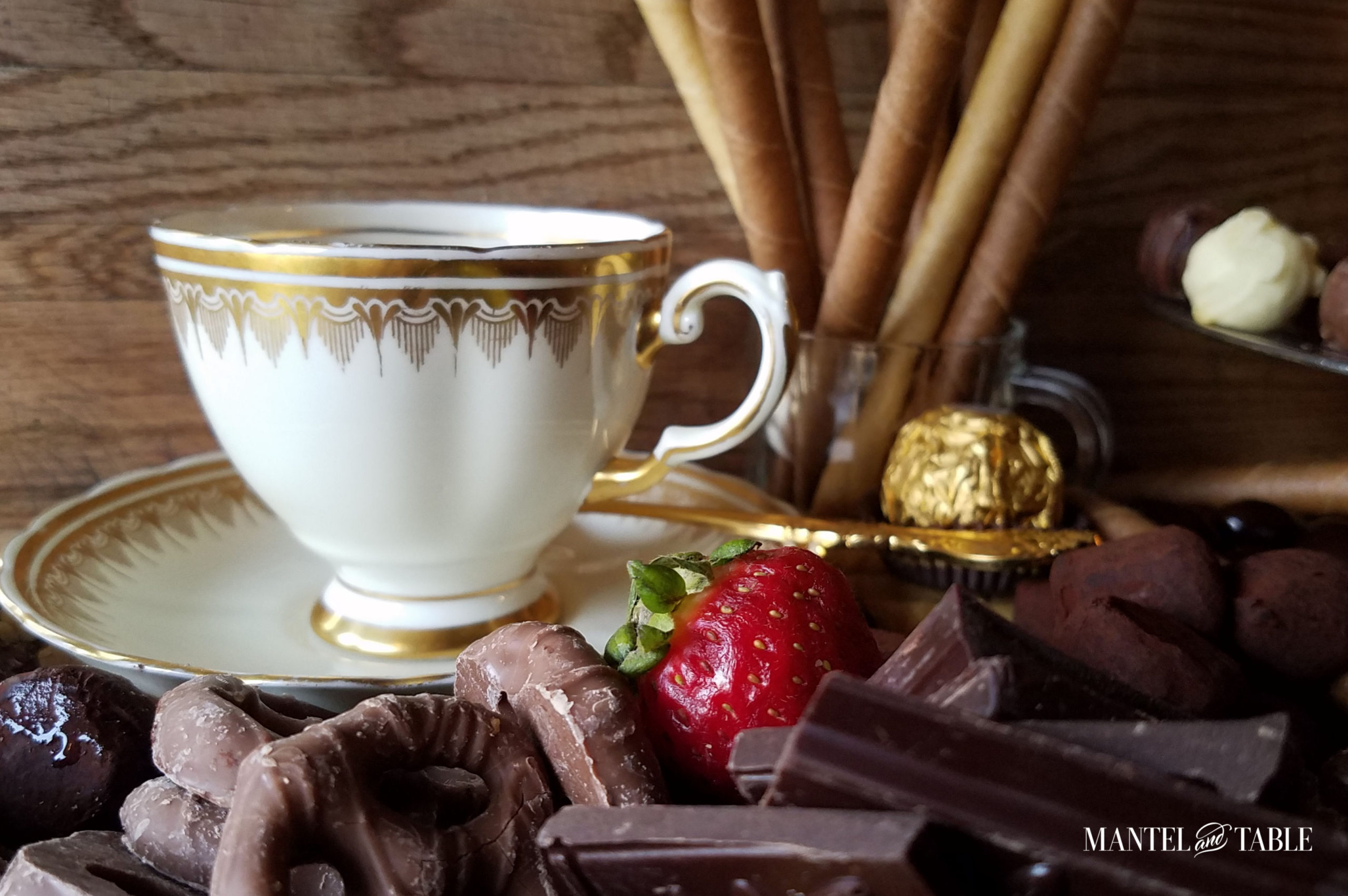 White and gold elegant teacup closeup with chocolates.