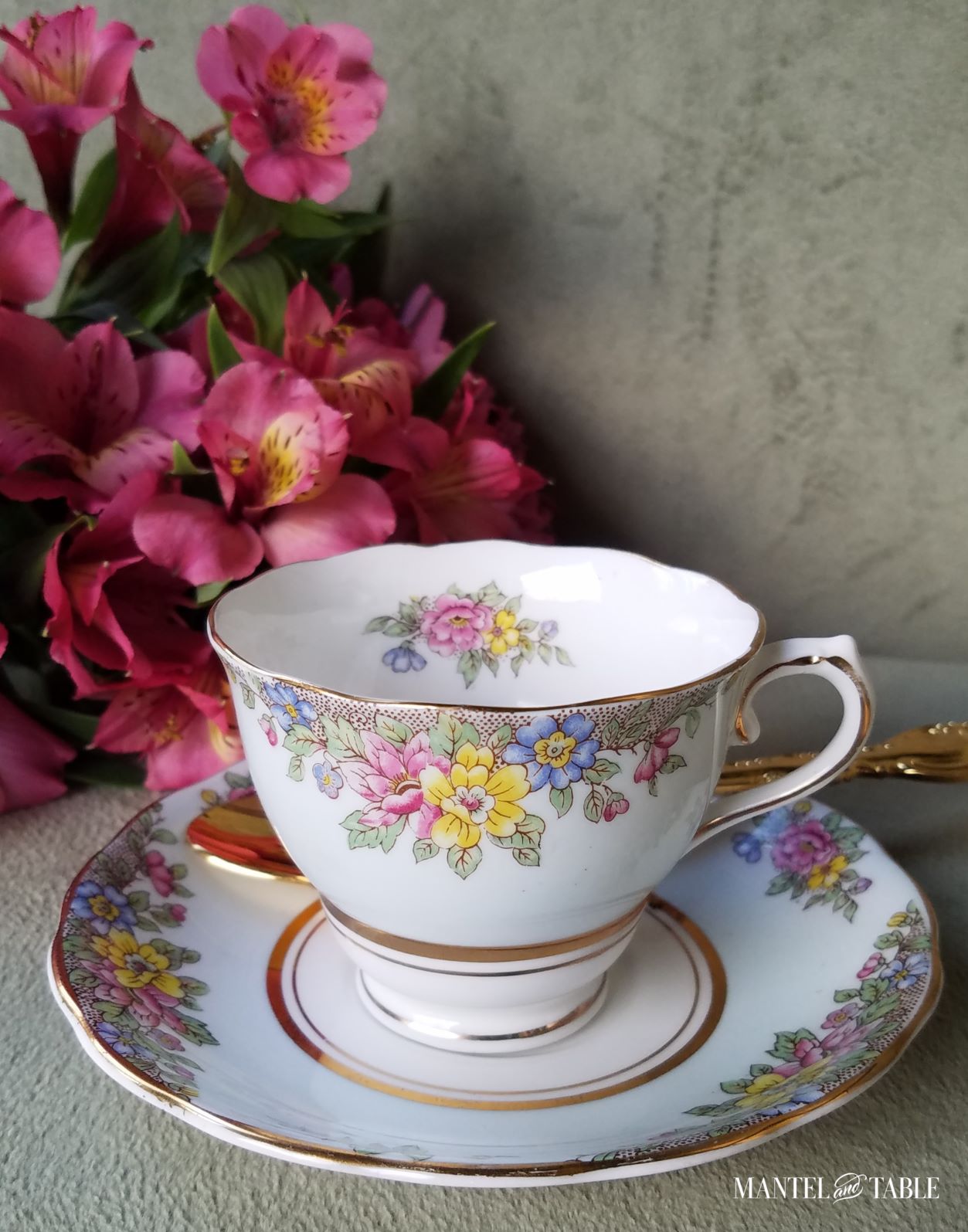 Blue flowered teacup and saucer with gold spoon