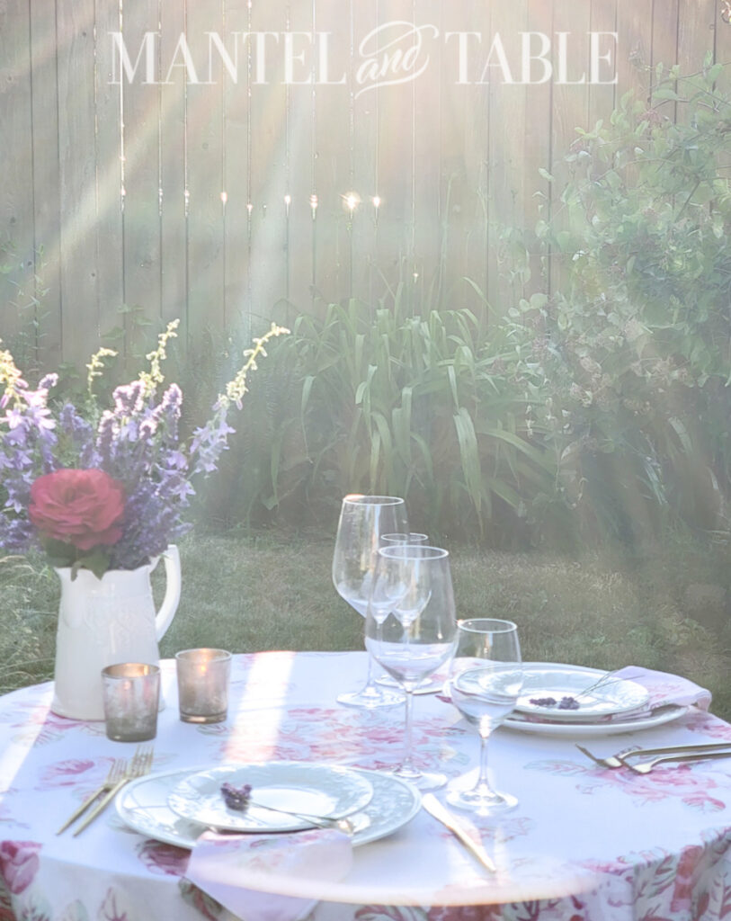 lavender bouquet centerpiece on outdoor dinner table with sunlight coming through fence in background