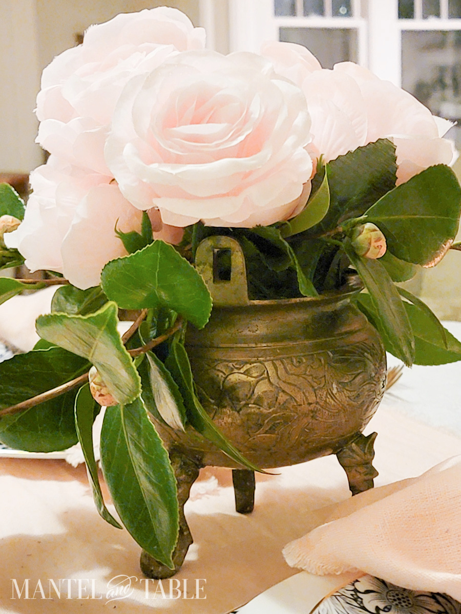 Closeup of pink rosse centerpiece in brass pot