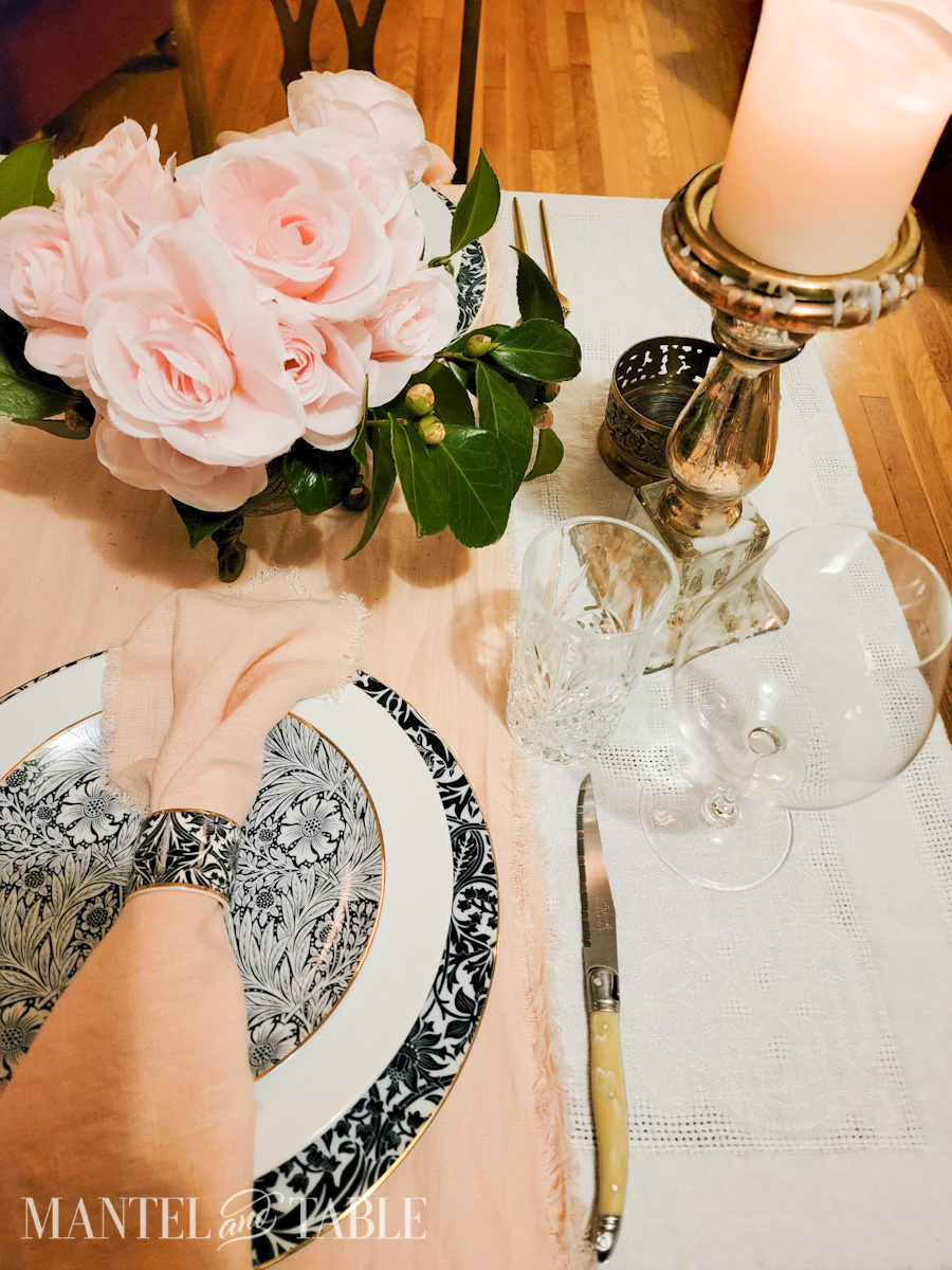A steak knife beside a plate stack on a formally set table