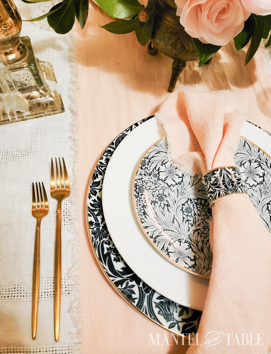 Closeup of gold forks beside plate stack on a table