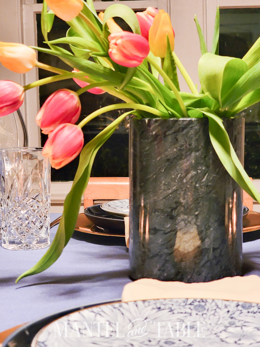 Closeup of dark grey marble wine chiller holding flowers on a table