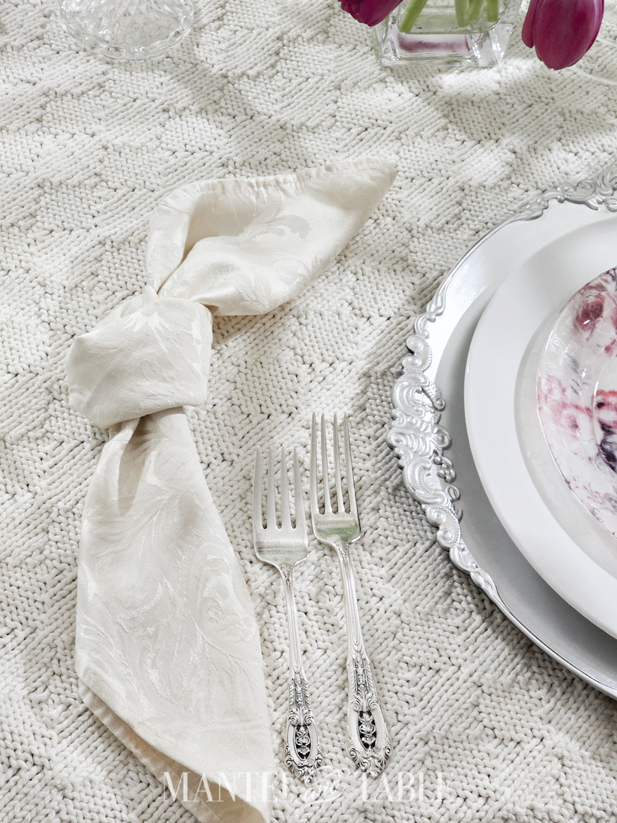 Closeup of cloth napkin tied in a loose knot that looks like bunny ears