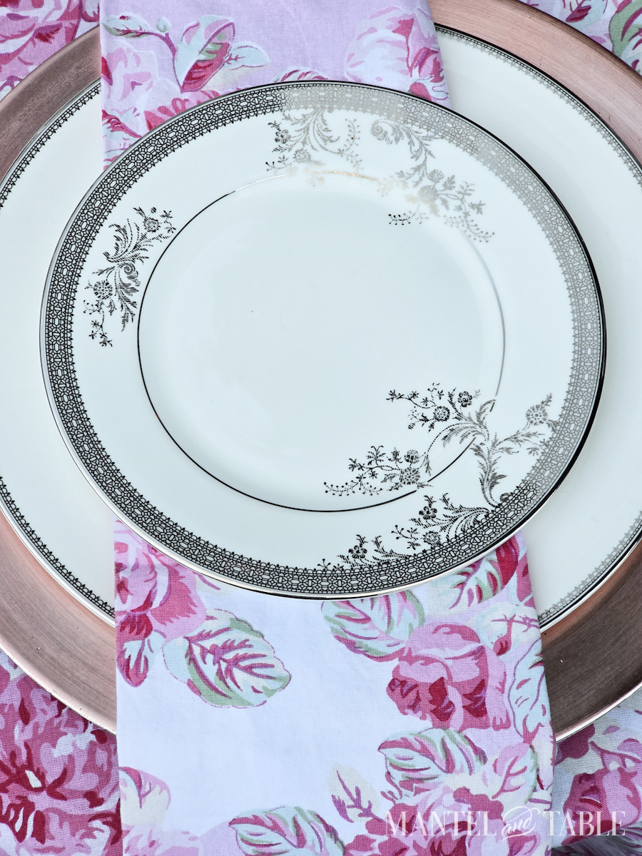 Closeup of white and silver china in a formal place setting